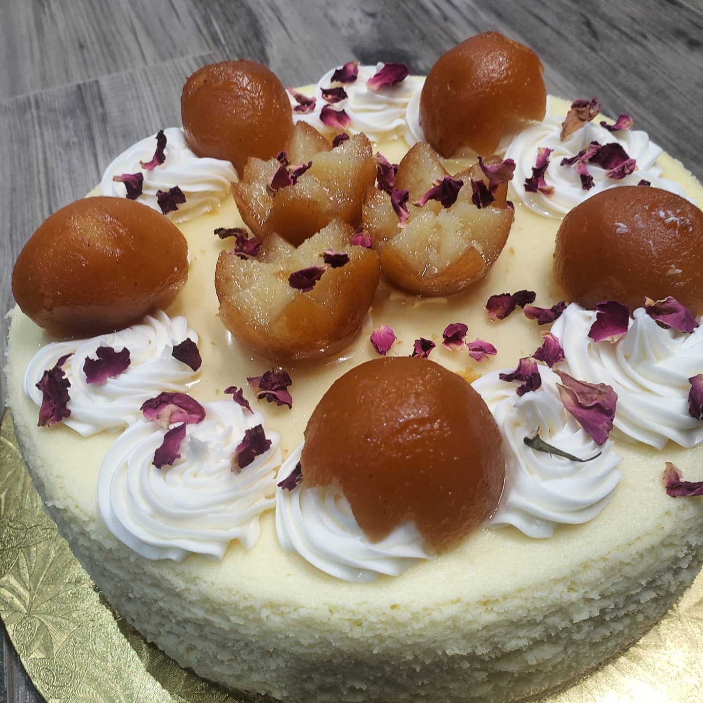 Close-up cheesecake gulab jamun avek petal rose