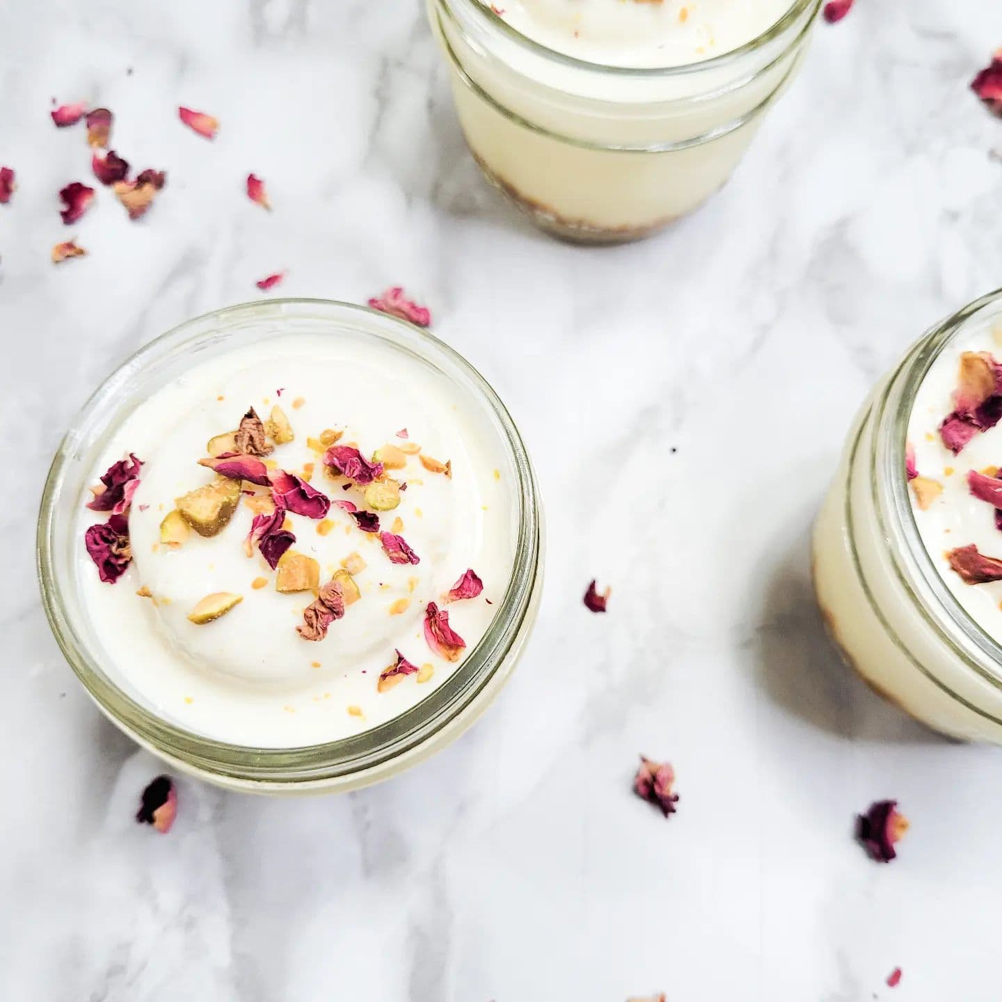 Cups cheesecake avek petal rose ek topping pistache
